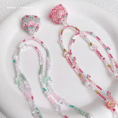 Beaded necklace  with pink and green beads on a white surface