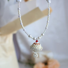Pearl necklace with a decorative pudding pendant on a blurred background