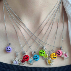 Necklace with colorful emoji pendants on a person's neck