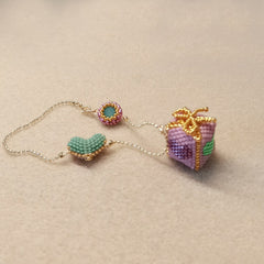 pink beaded gift box bag charm  on a beige background