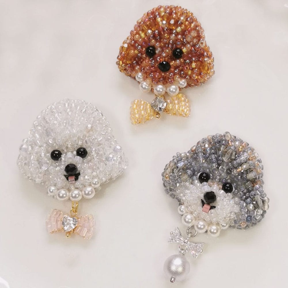 Three poodle dog brooches with crystal and pearl details on a white background - Verhalo Custom Jewelry