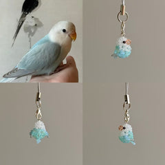 Beaded parakeet charm with a real parakeet for scale on a neutral background