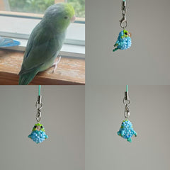 Green parakeet next to a beaded charm resembling the bird, with a plain background.