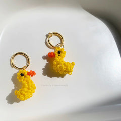 Yellow beaded duck earrings on a white background