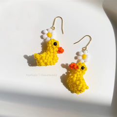 Yellow duck-shaped earrings with flowers on a white background