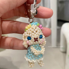 Handmade beaded keychain shaped like a rabbit held by a hand.
