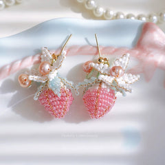 Pink beaded strawberry earrings on a white background