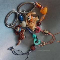 Colorful beaded keychain with animal figures on a gray background