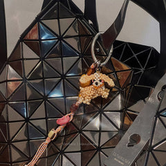 Keychain with a bear design attached to a geometric-patterned bag