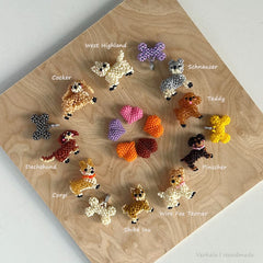 Collection of dog-shaped charms on a wooden board with labels for each breed.